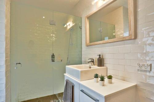 y baño con lavabo y ducha acristalada. en Spacious 3 Bedroom House Darlinghurst City Centre 2 E-Bikes Included en Sídney