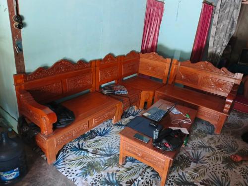 1 cama de madera con escritorio y ordenador portátil. en Omah Ngiyup en Semarang