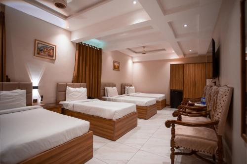 Pearl Inn Hotel في كراتشي: غرفة فندقية بسريرين وكرسي