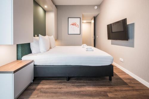 um quarto de hotel com uma cama e uma televisão em YAYS Amsterdam North by Numa em Amesterdão