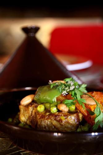 a plate of food with meat and vegetables at Les Jardins De La Koutoubia in Marrakech