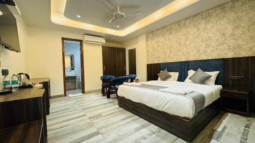 a hotel room with a bed and a kitchen at Raksha Suites & Banquet Greater Noida in Greater Noida