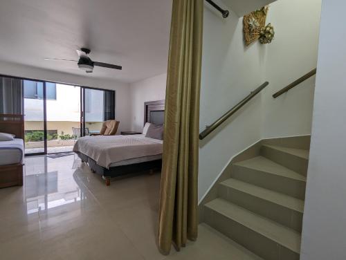 ein Schlafzimmer mit einem Bett und einer Treppe in einem Zimmer in der Unterkunft Villa Aurora Beautiful Beachfront Apartment in Cancún