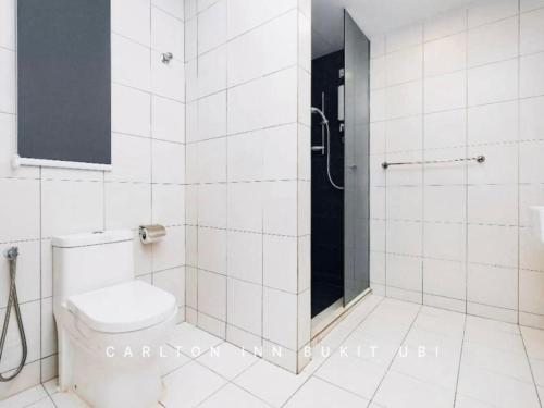 een witte badkamer met een toilet en een douche bij OYO 89492 Carlton Inn Bukit Ubi in Kuantan
