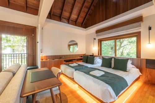 ein Schlafzimmer mit einem großen Bett und einem Sofa in der Unterkunft Sankara Hotel & Spa Yakushima in Yakushima