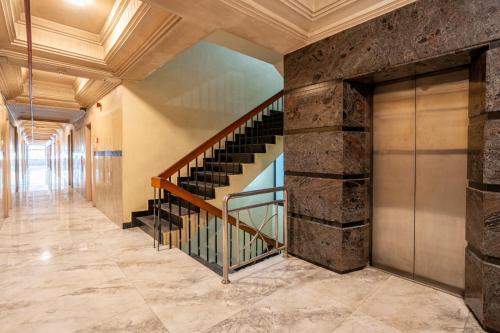 a staircase in a building with a stone wall at Sree Bharani Hotels in Tirunelveli