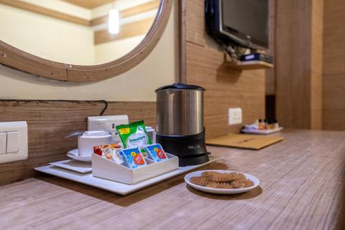 a counter with a coffee maker and a plate of food at Sree Bharani Hotels in Tirunelveli