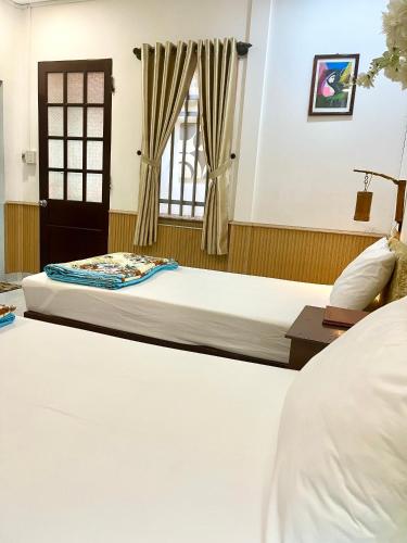 a bedroom with two beds and a window at Homestay MINH TÚ in Hue