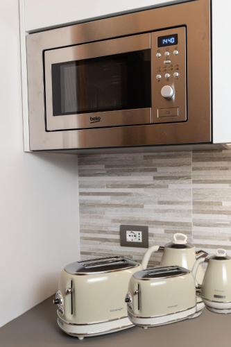 a microwave above a stove with two toasters at Gomes Comfort House 2 in Valeggio sul Mincio