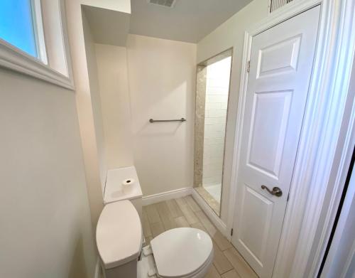 a white bathroom with a toilet and a shower at Entire Basement Apartment in Mississauga, Etobicoke in Mississauga