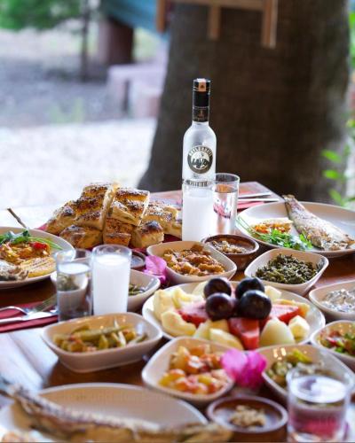 a table with plates of food and a bottle of wine at Murat Pasha Mansion in Dalyan