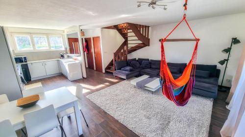 a living room with a hammock hanging from the ceiling at Duplex à 2 pas de l'aéroport, proche ONU & Palexpo in Ferney-Voltaire