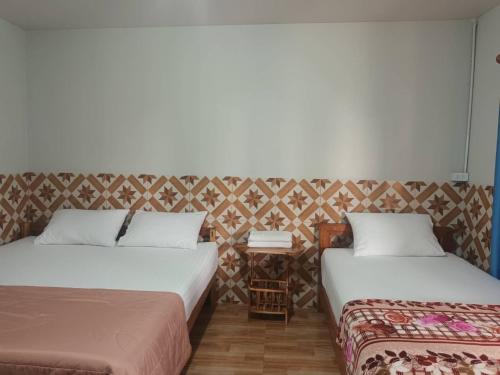 2 Betten nebeneinander in einem Zimmer in der Unterkunft Noppakao Resort in Soem Ngam