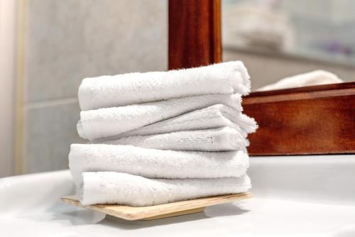 a stack of towels sitting on a bathroom sink at Casa Olimpia in Savona
