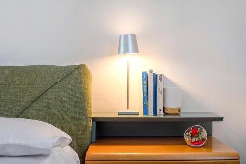 a bedside table with a lamp and books on it at Casa Olimpia in Savona