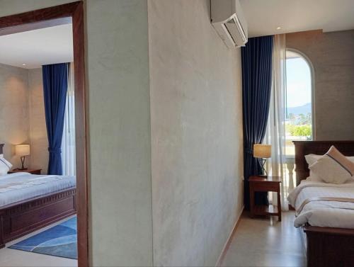 a hotel room with two beds and a window at Sokchea Kampot Hotel in Kampot