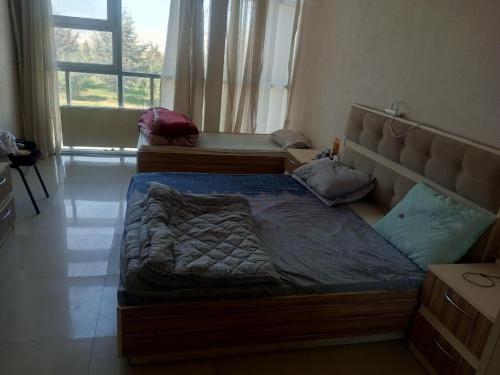 een slaapkamer met 2 bedden en een groot raam bij Lahore Hotel Baku in Baku