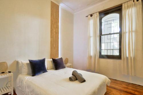 una camera da letto con un letto con cuscini blu e una finestra di Affordable 2 Bedroom House Surry Hills 2 E-Bikes Included a Sydney