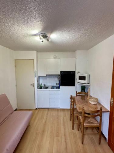 a living room with a table and a kitchen at Studio Pablotin d’Abriès in Abriès