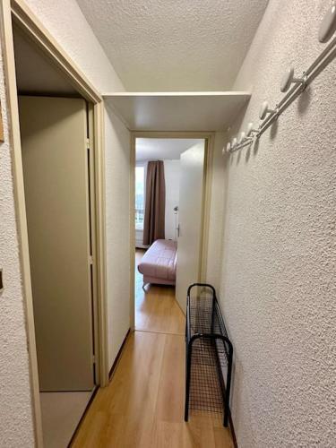 a hallway with a door to a room with a bed at Studio Pablotin d’Abriès in Abriès