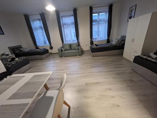 a large room with a table and chairs and windows at Penzion Grand Nymburk in Nymburk