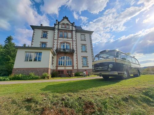 Château Robert في راوْ لوتاب: حافلة قديمة متوقفة أمام مبنى
