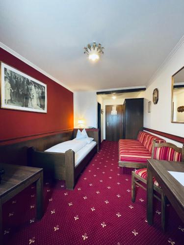 a hotel room with a bed and a couch at Landgasthof Santner in Thalgau