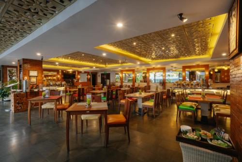 a restaurant with tables and chairs and a bar at Horison Ultima Seminyak Bali - CHSE Certified in Seminyak