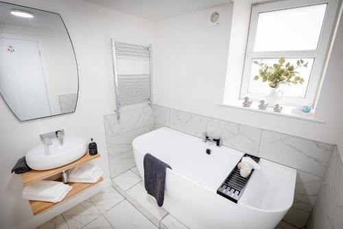 a white bathroom with a sink and a mirror at Kings Arms Suites - Luxury Double - Freestanding Bath - Self Check In in Whitehaven