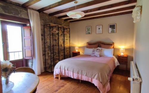 a bedroom with a bed and a table and a window at Posada La Dalia in Castillo-Pedroso