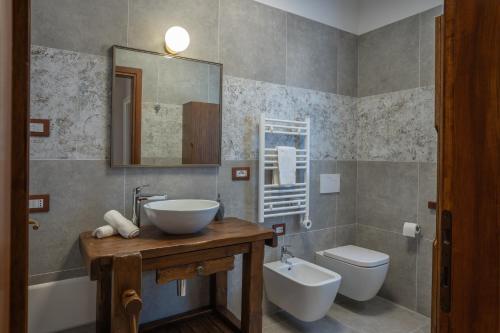 a bathroom with a sink and a toilet and a mirror at Gomes Comfort House 2 in Valeggio sul Mincio