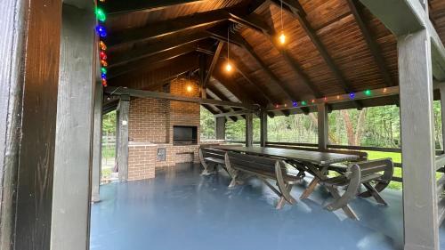 einen Picknicktisch und Bänke in einem Pavillon in der Unterkunft Mountain Paradise & Wellness in Izvoare