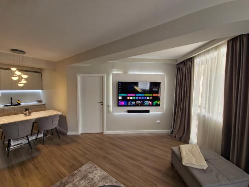 a living room with a table and a television on the wall at Royal Trip Luxury Apartment Sinaia in Sinaia