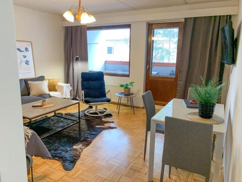 a living room with a table and a dining room at Tilava 2BR-huoneisto Saunalla in Oulu