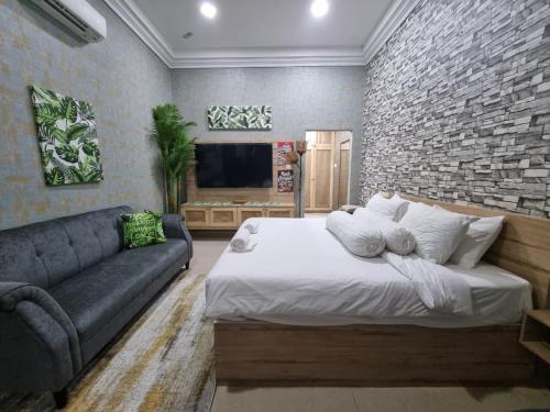 1 dormitorio con 1 cama grande y 1 sofá en OYO 89849 Sekin Hotel And Resort, en Kuala Selangor