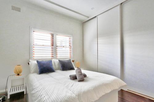 ein Schlafzimmer mit einem Bett mit einem Teddybär drauf in der Unterkunft Spacious 3 Bedroom on the edge of Downtown Herford St 2 E-Bikes Included in Sydney