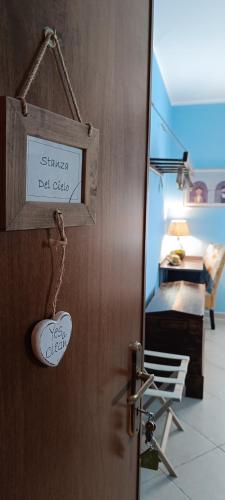 a wooden door with a heart shaped sign on it at Il Sentiero B&Bìo in SantʼAntìoco