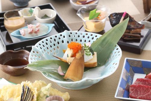 a bowl of food on a table with sushi at Hotel Binario Saga Arashiyama in Kyoto