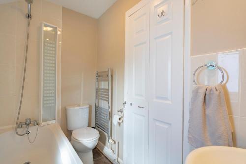 a bathroom with a tub and a toilet and a sink at Cornish Holiday - Meadow Rise in Saint Columb Major
