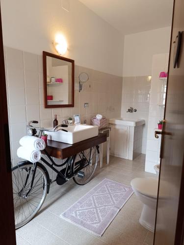 a bathroom with a bicycle and a sink and a toilet at Il Sentiero B&Bìo in SantʼAntìoco