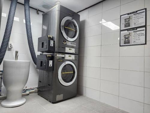 eine Waschmaschine und ein WC in einem Zimmer in der Unterkunft New Cheonji Hotel in Seoul
