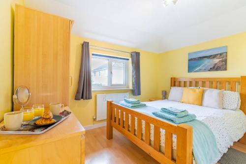 Un dormitorio con una cama con una bandeja de comida. en Cornish Holiday - Meadow Rise, en Saint Columb Major