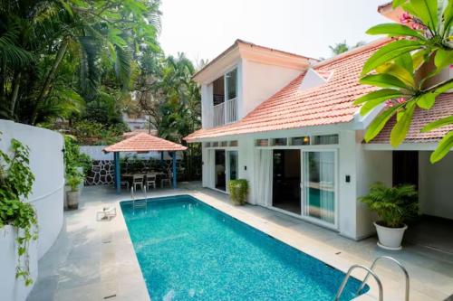 a villa with a swimming pool and a house at Aguada Anchorage - The Villa Resort, Candolim in Candolim