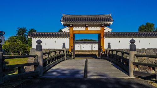 a wooden bridge with a gate in front of a building at Toyoko Inn Yamagata-eki Nishi-guchi in Yamagata