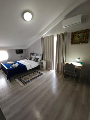 a bedroom with a bed and a table and a desk at Hotel Tradicia in Tbilisi City