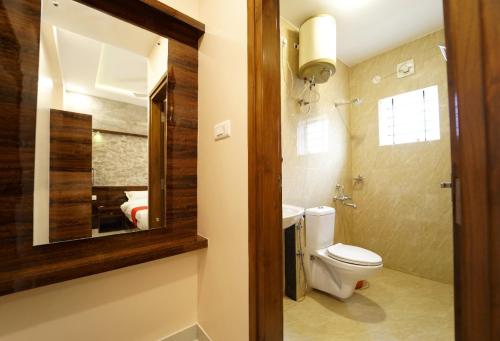 a bathroom with a toilet and a mirror at SS CROWN inn in Bangalore