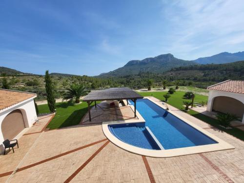a pool with a gazebo next to a house at Villa con piscina privada - Benimarraig in Benissa