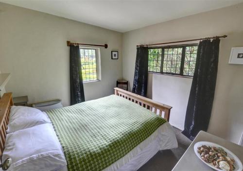 a bedroom with a bed and a bowl of food on a table at The Gatehouse in Llanrwst