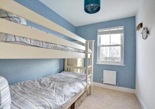 サンダースフットにあるTy Glas (The Blue House)のベッドルーム1室(二段ベッド2台、窓付)が備わります。