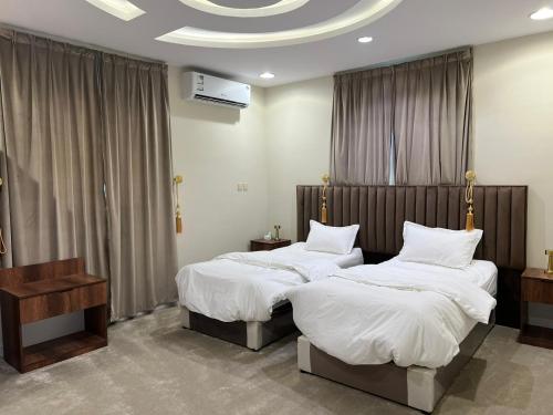 two beds in a hotel room with at السلطان للشقق المفروشة in AlUla